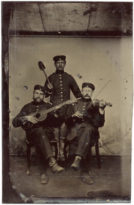 Drei Männer in Uniform mit Instrumenten und Klobürste