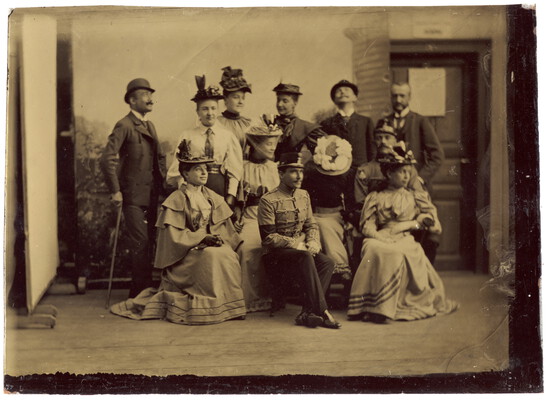 Gruppe in Kostümen vor einer Häuserkulisse, vermutlich in einem improvisierten Fotostudio