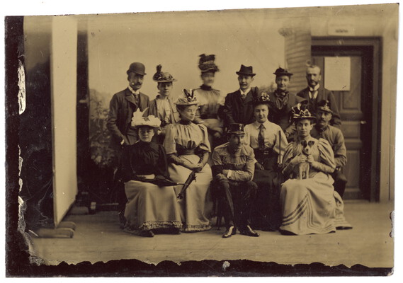 Gruppe in Kostümen vor einer Häuserkulisse, vermutlich in einem improvisierten Fotostudio