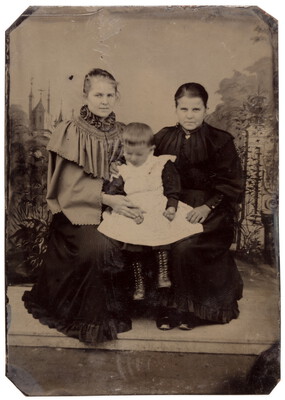 Zwei Frauen mit einem kleinen Kind posieren im Atelier